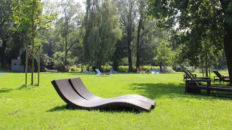 Design-Liege auf sonniger Liegewiese im Garten des Hotel Schwedi – entspannen unter Bäumen in natürlicher Ruhezone am Bodensee.