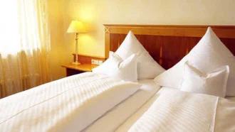 Die Elizabeth Suite im Hotel Schwedi mit elegantem Doppelbett, warmem Licht und hochwertiger Bettwäsche.