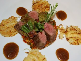 Rosa gebratenes Lammkarree auf Gemüse mit Kräuterkruste, serviert mit Rösti und Jus – raffiniertes Hauptgericht aus der gehobenen Küche im Hotel Schwedi.