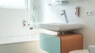 Hell gestaltetes Tageslicht-Badezimmer im Hotel Schwedi mit Badewanne, wandhängendem WC und modernem Waschtisch