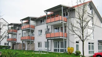Ferienhausanlage des Hotel Schwedi mit mehreren Wohneinheiten, Balkonen und gepflegter Grünfläche – ideal für Familien und Langzeitgäste.