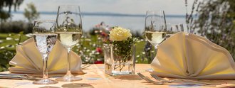 Gedeckter Tisch auf der Terrasse des Hotel Schwedi vor der Kulisse des Bodensees. 