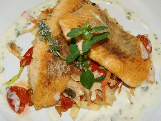 Kross gebratene Fischfilets auf Gemüsenudeln mit Kräutersahnesoße, serviert im Restaurant des Hotel Schwedi – frische, regionale Küche mit mediterranem Akzent.