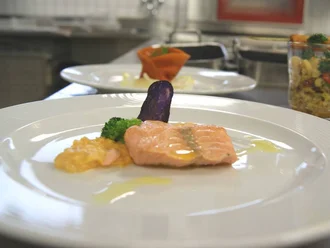 Ansprechend angerichtetes Lachsfilet mit Gemüse und Sauce im Restaurant des Hotel Schwedi – feine Gourmetküche mit kreativer Präsentation.